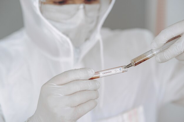 Man in protective suit and glasses working at laboratory