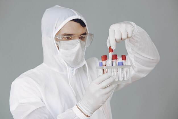 man in protective suit and glasses working at laboratory