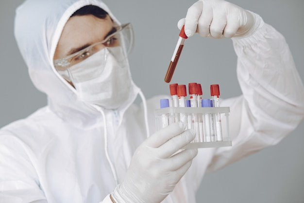 Man in protective suit and glasses working at laboratory