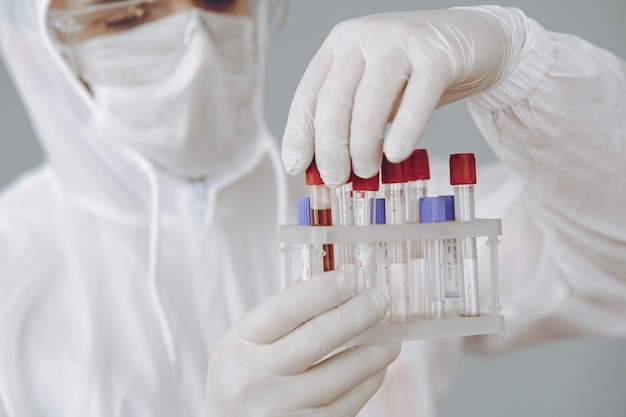 Man in protective suit and glasses working at laboratory