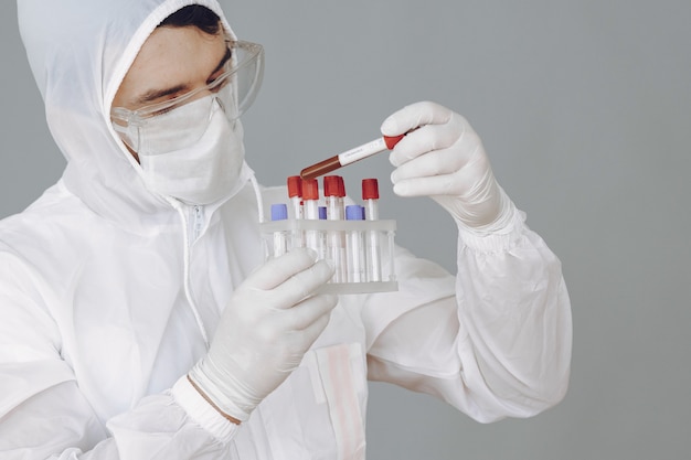 Man in protective suit and glasses working at laboratory