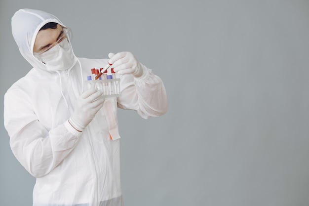 Man in protective suit and glasses working at laboratory