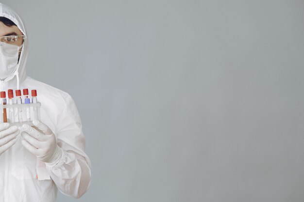 Man in protective suit and glasses working at laboratory