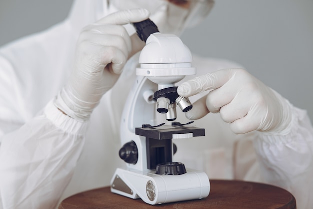 Man in protective suit and glasses working at laboratory