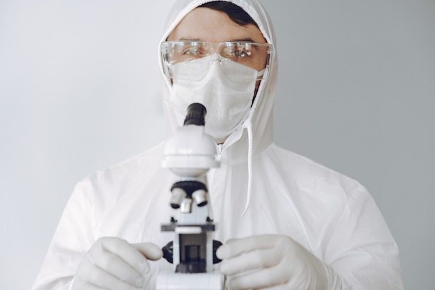 Человек в защитном костюме и очках, работающих в лаборатории