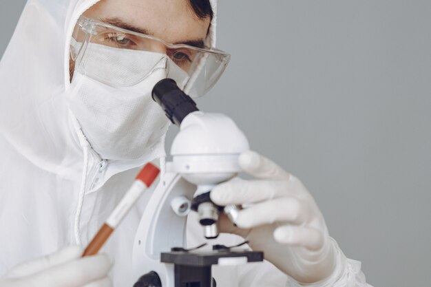 Man in protective suit and glasses working at laboratory