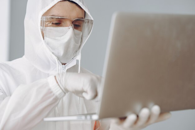 Man in protective suit and glasses working at laboratory