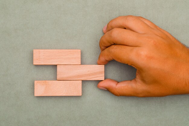 man pulling out wooden blocks