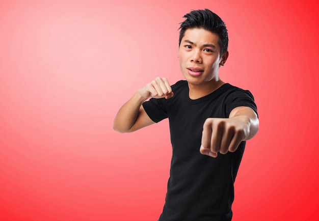 Free photo man punching on a red background