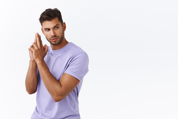 man in purple t-shirt, making finger pistol gesture, standing as holding gun like spy or secret agent, look suspicious aside