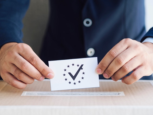 Man putting a ballot in a box