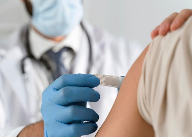 Man putting a bandage on a young woman's arm