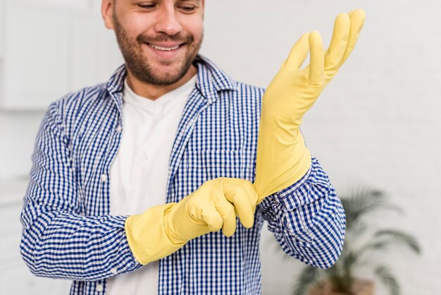 Man putting on cleaning gloves