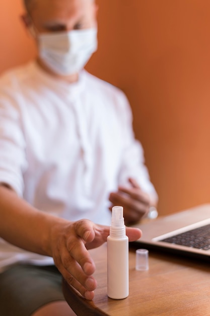 Uomo che mette giù una bottiglia di disinfettante