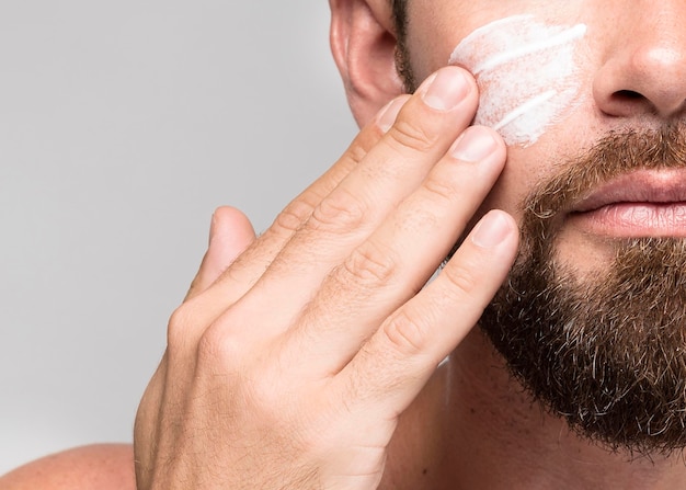 Man putting on face cream close-up