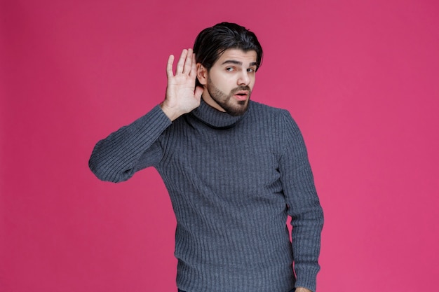 Man putting hands over his ears because of volume.