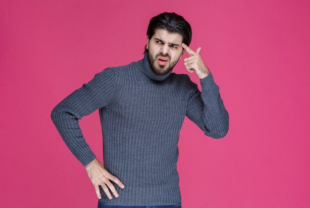 Man putting his hand towards his head and thinking.