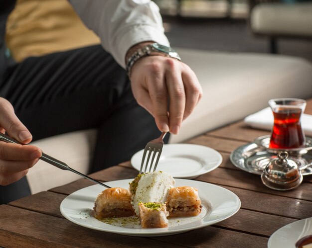 man putting an ice cream to the middle of turkish pakhlava