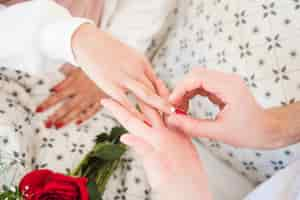 Free photo man putting ring on finger of woman