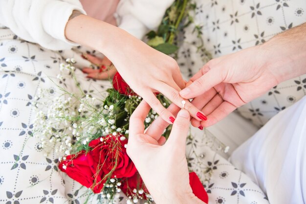 Man putting ring on hand of woman