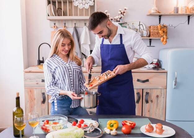 Man putting vegetables in pot 