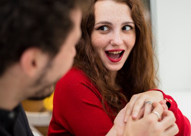 Man putting wedding ring on woman finger