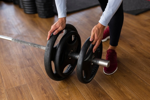 Free photo man putting weights on bar