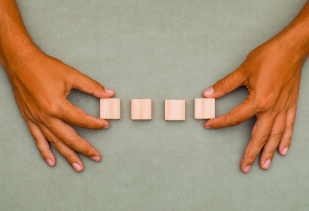 man putting wooden cubes in order.