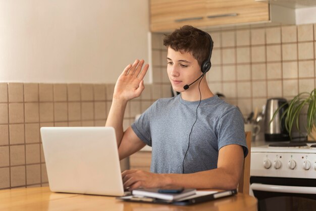 Man in quarantine in the kitchen working on laptop