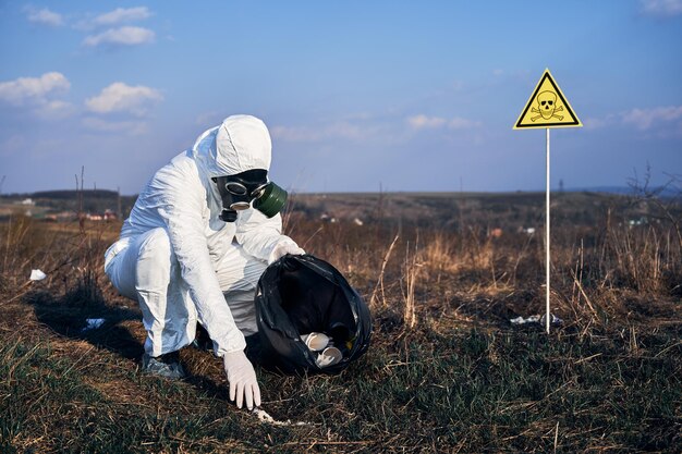 Man in radiation suit picking up trash on the street