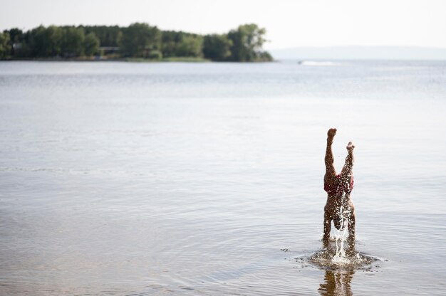 Man raising hands in lake