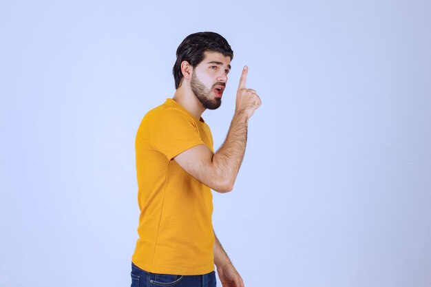 Man raising his hand up and pointing at something above