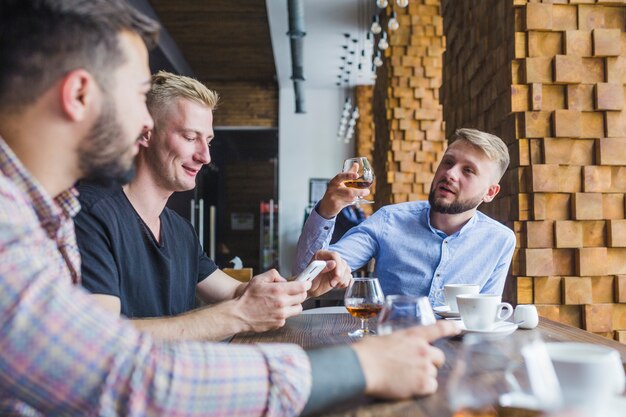 Мужчина поднимает тост со своими друзьями в ресторане