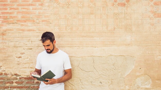 Man reading book against grunge wall