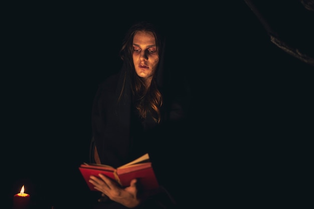 Man reading a spell book in the dark