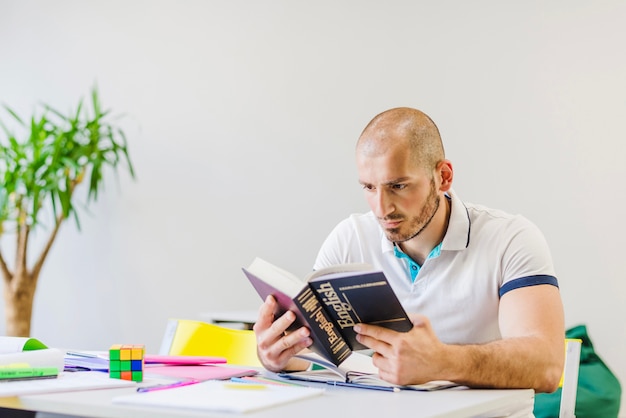 L'uomo legge il libro di testo con interesse