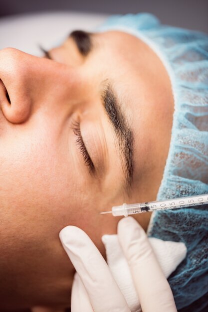 Man receiving botox injection on his face