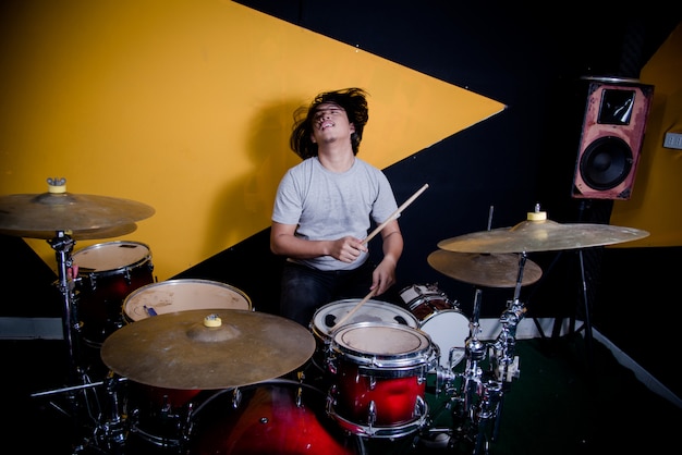 Free photo man recording music on drum set in studio