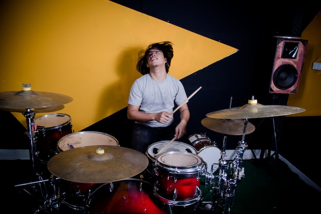 Man recording music on drum set in studio