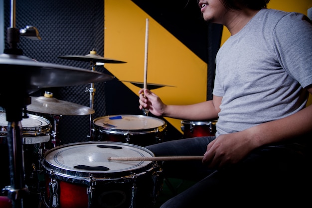 Man recording music on drum set in studio