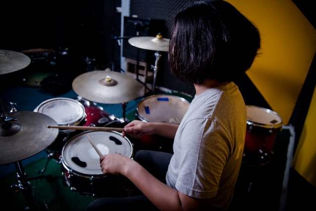 Человек записывает музыку на барабанной установке в студии