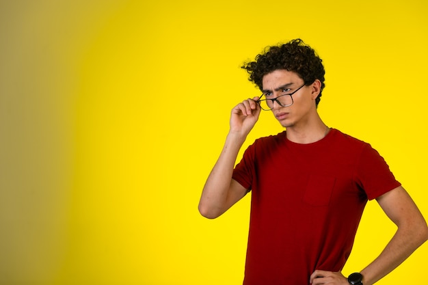 Man in red shirt wears his eye glasses and looks disappointed.