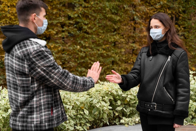 Free photo man refusing to shake hands outdoors