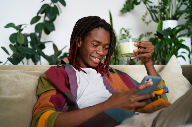 Free photo man relaxing at home and enjoying a cup of matcha tea