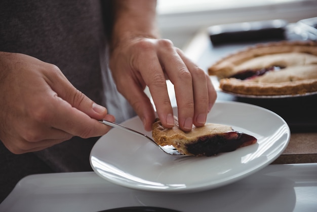 Man removing slice of blueberry tart