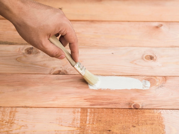 Man repairing floor damage using a brush