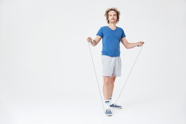 Man in retro sport outfit holding jumping rope in hand