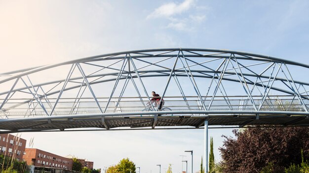 Man riding bicycle on bridge