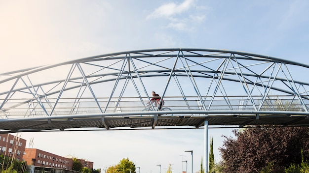Человек, верхом на велосипеде на мосту