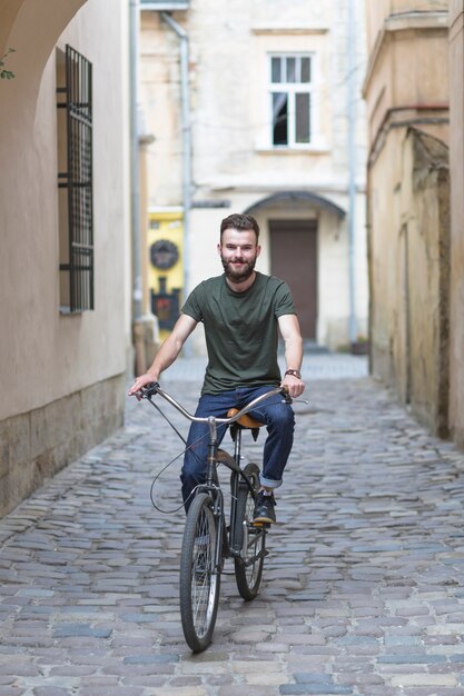Man riding bicycle on cobble stoned street